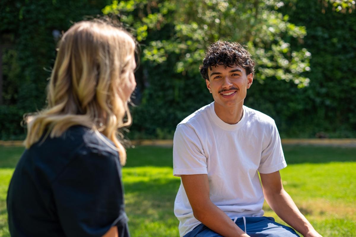 Male student sitting outside with female student