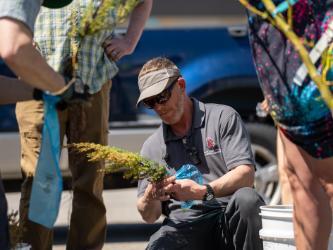 NIC Landscape Technician J.D. Reeves packages up a seedling for distribution during NIC’s Arbor Day event on April 29, 2023, in the Molstead Library parking lot at NIC’s Coeur d’Alene campus.