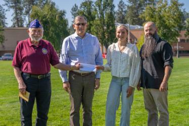 From left, Military Order of the Purple Heart representative Len Crosby, North Idaho College President Nick Swayne, NIC student Jayden Murphy and her father Daniel Porter pose for a photo at Eisenwinter Field on NIC’s Coeur d’Alene campus.